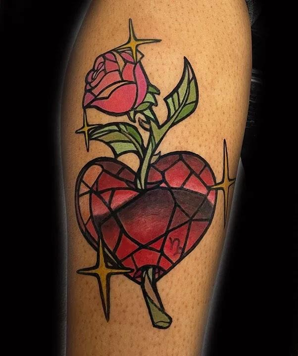 Red geometric heart tattoo with a rose growing from the top, outlined in black with sparkling star accents on the calf.