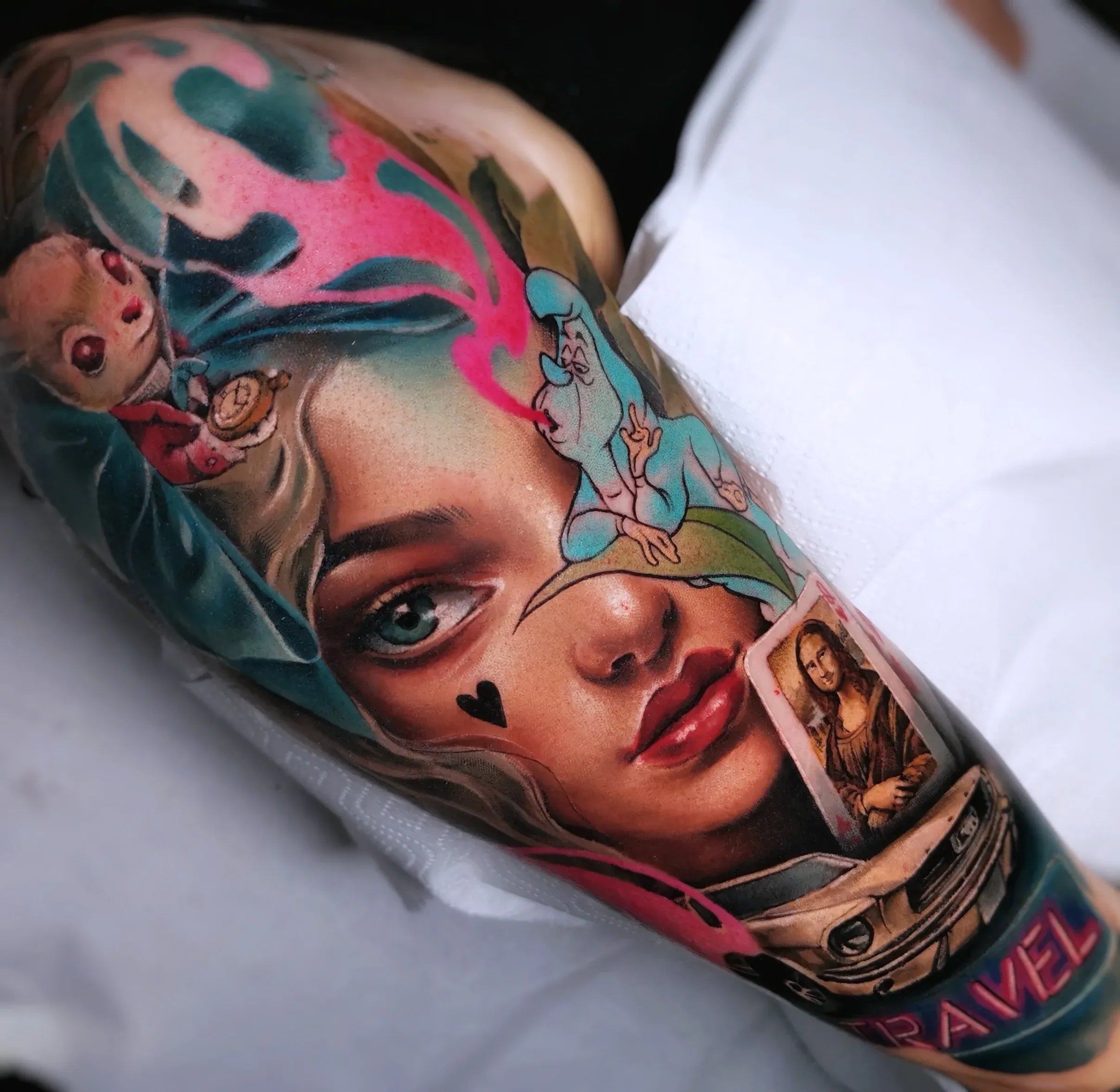 Vivid color realism tattoo sleeve featuring a woman's face surrounded by Alice in Wonderland characters and fine art.